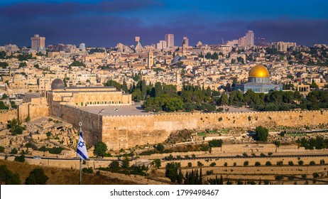 View of Temple Mount with Dome of the Rock and Al Aqsa Mosque, archaeological park of the Southern Wall and Huldah Gates, and skyline of new Jerusalem over the Old City; with Israeli flag in the front