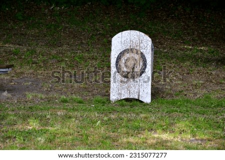 A view of a temporary shooting range prepared for an archery and crossbow competition with targets made out of rolled hay on wooden stands with the background being a cloth hanging from two sticks