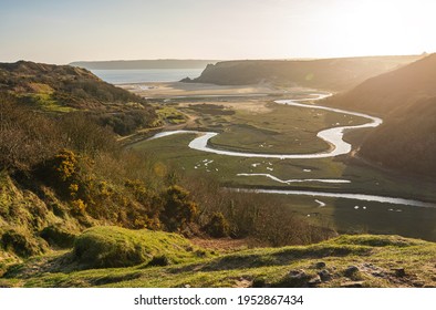 View of Three Cliff's Bay and Penard pill river at sunset in spring, Gower, Swansea, South Wales, UK