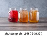 A view of three mason jars filled with iced teas.