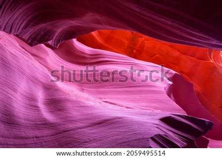 View up through antelope canyon in Arizona, showing a spectrum of colors from red and pink to orange, highlighting eroded rock textures