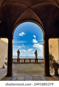 view through arched balcony with classical statues in Italian villa. Bergamo. 
