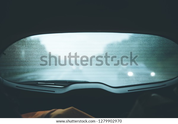 View through\
the back window of a car, rainy\
day