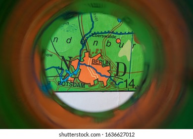 View Through Binoculars, Focused On The German Capital Berlin. Part Of An Old Map, Showing The Iron Curtain And The Wall Through The City. 