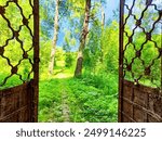 A view through broken doorway in a ruined building, showcasing a pathway leading to a forest