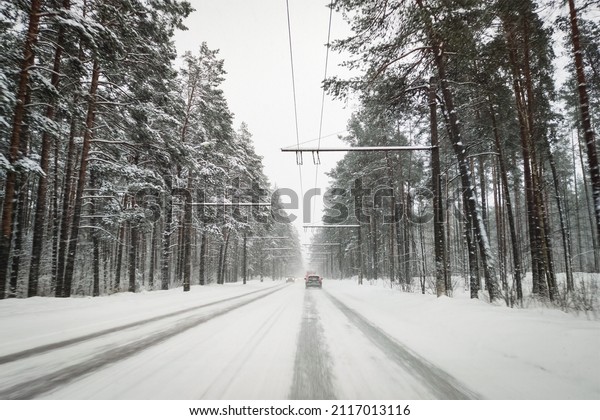 View through the car windshield. Driving a car on\
a snowy road in winter.