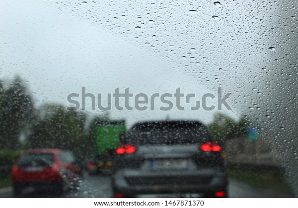view through a\
car windshield in raining\
day