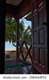 View through the door of a chalet on the beach with a coconut tree in Tioman Island, Malaysia, a tropical paradise