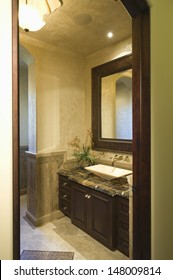 View Through Doorway To Dark Brown Bathroom Unit With Mirror Frame