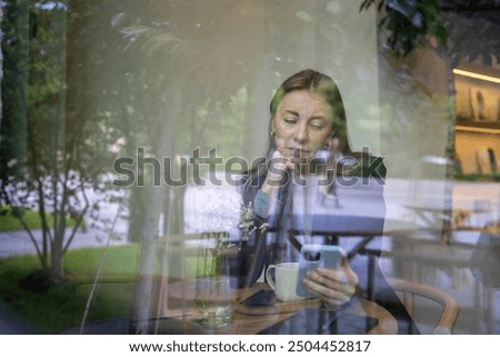 Similar – Young woman looking at cellphone