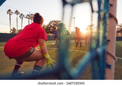 View Through Goal Net Of Womens Football Team Playing Soccer Match