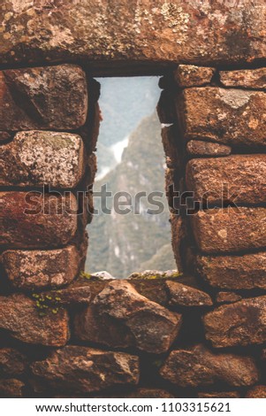 View through Inca window in Machu Picchu, Peru, South America. Archaeological site. April, 2018.