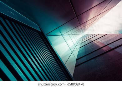 View through modern high rising skyscraper chimney upwards to blue sky with white clouds - abstract architecture detail background in turquoise teal blue to burgundy purple colors - Powered by Shutterstock