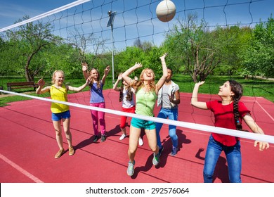 View through net on game of girls playing together