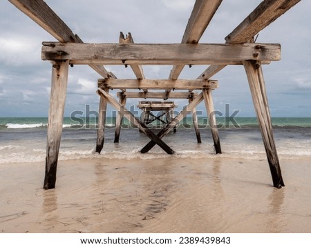 View through old dilapidated pier out to sea