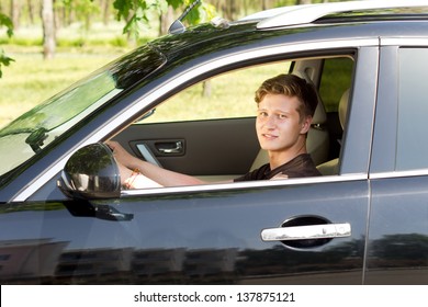 View Through The Open Side Window Of A Smiling Handsome Young Man Driving A Car In Countryside