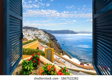 View through an open window of the Aegean Sea, caldera and town of Oia and Thira on the island of Santorini Greece.