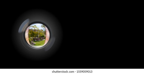 View through peephole in door looking out to entry security surveillance concept solid black background