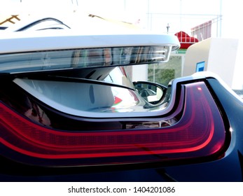 view through the red tail light of a modern sports car on a public street in Budapest with blurry background. style and lifestyle concept. luxury and commercialism theme. original design ideas.