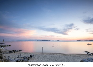 View through rocks on a sandy beach into the sunset. Landscape shot with a view to the horizon over the wide sea on the coast of Ouranoupoli, Thessaloniki, Central Macedonia, Greece - Powered by Shutterstock