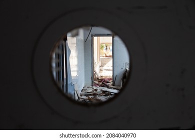 View through the round hole in the door on the Scary empty dark corridor in an abandoned building. Shabby walls. The play of light and shadows in an abandoned house. Broken doors. - Powered by Shutterstock