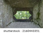 View through shooting manhole to the outside. An old fortification fragment from the First World War, made from concrete with a lope hole - the small opening through which fired with a machine gunner.