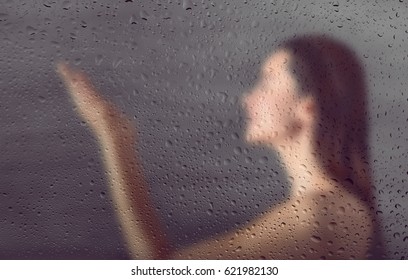 View Through Steamy Glass On Young Woman In Shower