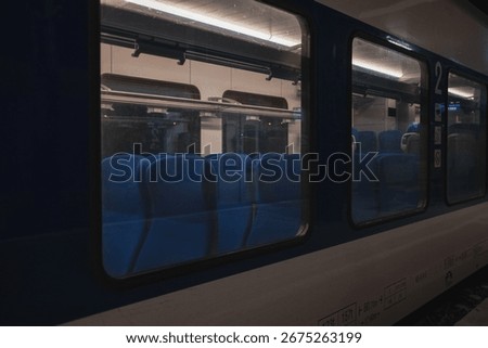 View through the train window showing empty blue seats in a second-class carriage at night in Serbia