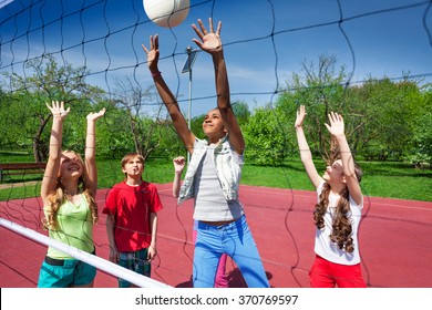 View through volleyball net of playing children