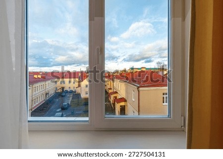 View through a white plastic window of an old town European street
