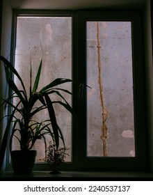 

View through window onto a  decrepit wall

