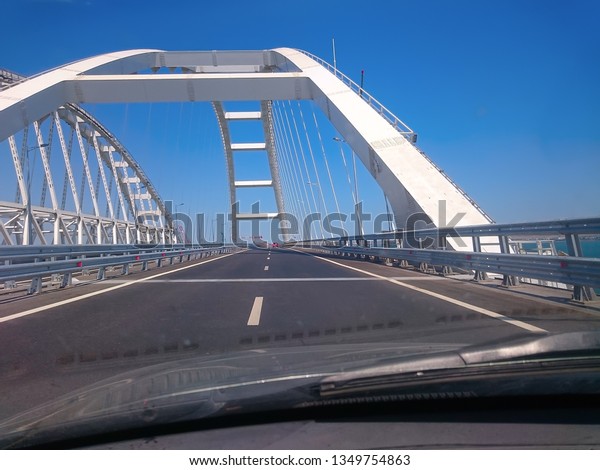 View through the windshield of a moving car.\
Crimea, Russia - June, 8, 2018: Travel on the Crimean bridge during\
its construction. View from the\
car