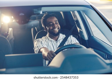 View through a windshield of a multicultural driver driving his classy car in traffic on a city street.