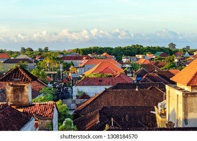 View of tiled roofs. Bali houses. Top view at small town, sunset.