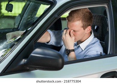 View Of Tired Businessman Driving A Car