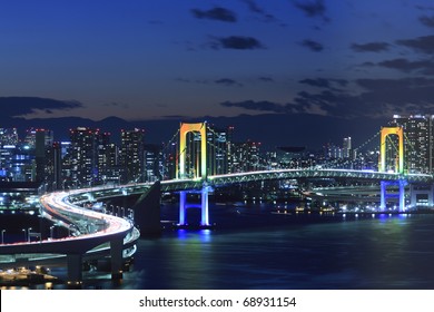 View of Tokyo downtown at night with Rainbow Bridge - Powered by Shutterstock