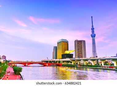 View Of The Tokyo Skyline Along The River At Dusk.