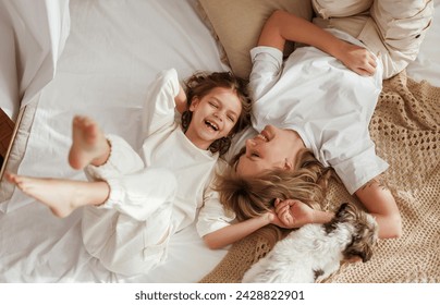 View from the top, lying down on bed. Mother with daughter are at home together. - Powered by Shutterstock