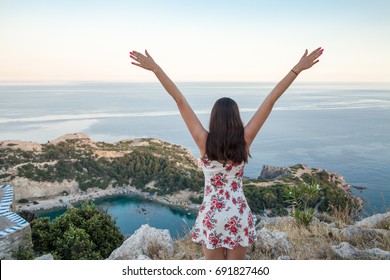 View from top on Anthony Quinn Bay and beach, Rhodes in Faliraki, Greece. Happy girl Raising One Hand. Beautiful beach and bay on the island of Rhodes. 