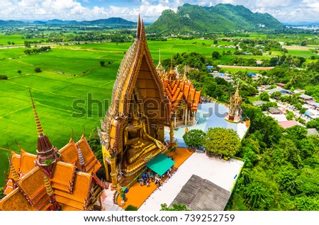 A view from the top of the pagoda, golden buddha statue with rice fields and mountain, Tiger Cave Temple (Wat Tham Seua) Thai and Chinese temples in Kanchanaburi province.public location