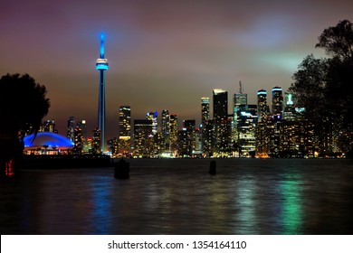 View of the Toronto city skyline from the Toronto Islands at night. City lights reflected in clouds and lake. - Powered by Shutterstock