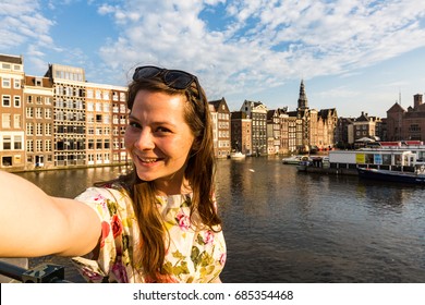 View Of A Tourist Girl On Sunset At The Damrak Square In Amsterdam