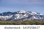 View towards the top of Mt Hamilton on a clear winter day, snow covering the summit and the surrounding hills; San Jose, San Francisco bay area, California