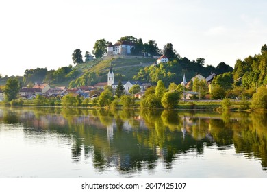 View of town of Sevnica and Sevnica castle in Slovenia above woth river Sava with a refelction of the town in the water 