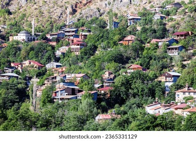 View of traditional Erzincan Kemaliye houses during the summer season. These houses, built on steep cliffs, are still used today. - Shutterstock ID 2365331129