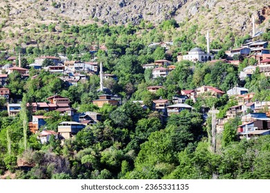 View of traditional Erzincan Kemaliye houses during the summer season. These houses, built on steep cliffs, are still used today. - Shutterstock ID 2365331135