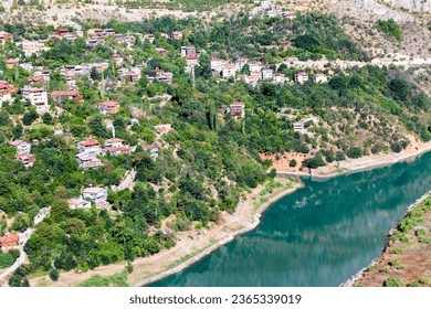 View of traditional Erzincan Kemaliye houses, the Dark Canyon and Euphrates River, during the summer season. These houses, built on steep cliffs, are still used today. - Shutterstock ID 2365339019