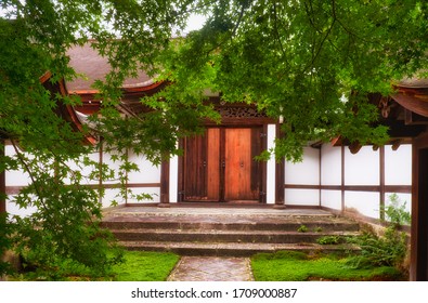 The View Of The Traditional Japanese Buildings And Gate To The Ryoan-ji Temple Through The Emerald Green Lace Of Maple Leaves. Kyoto. Japan