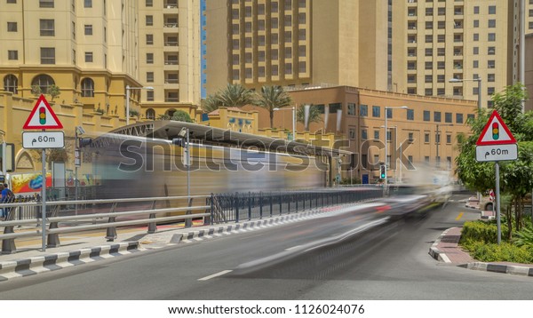 A view of traffic on the street at Jumeirah Beach\
Residence and Dubai marina timelapse, United Arab Emirates. Tram\
moves near tram stop. JBR is the largest single phase residential\
development in the