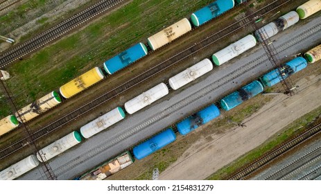 View Of The Trains From Above. Multi-colored Tanks For The Storage And Transportation Of Petroleum Products, Chemically Active And Aggressive Liquid Substances. Railway Tanks Of A Freight Train.